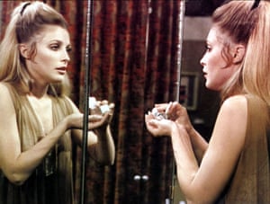 One of the women from 'Valley of the Dolls' stares at herself in the mirror and pours pills into her hand.