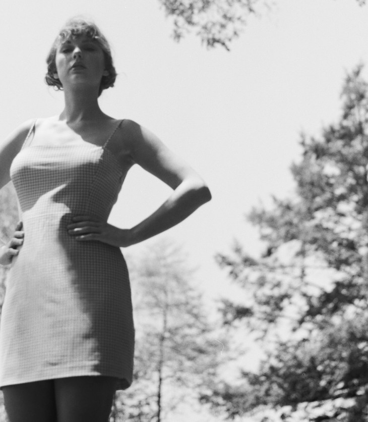 Image from Folklore album, Taylor Swift poses in a wooded area