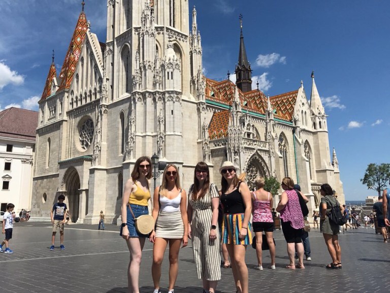 A group of women in front of a cathedral