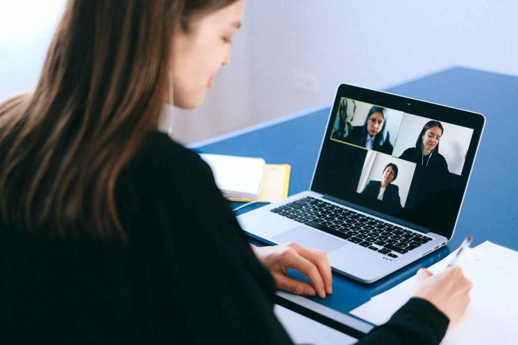 A woman has a video call with colleagues.