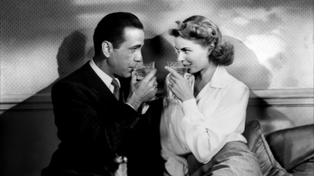 The two characters from 'Casablanca' drink and stare into each other's eyes.