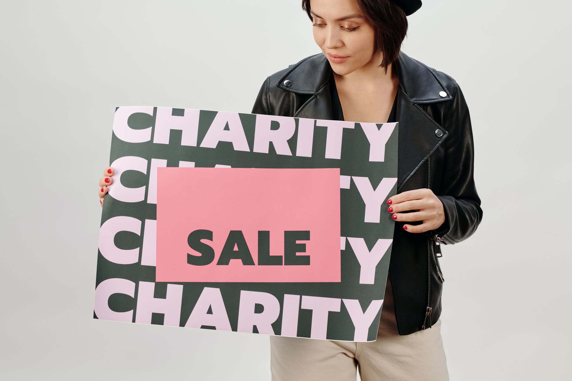 woman in black leather jacket holding green and white charity sign