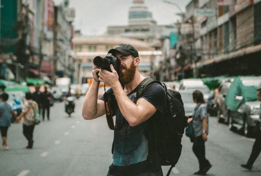 A man takes a photograph in a busy street.