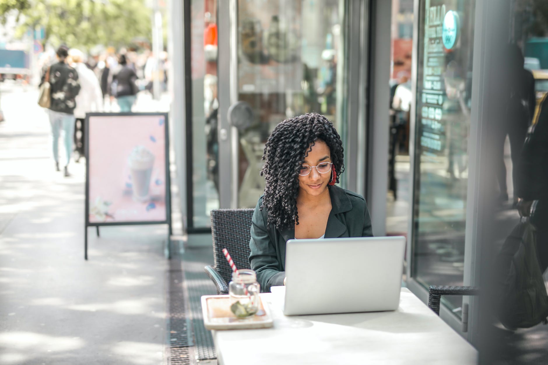Woman starts her own blog on a laptop outside a café