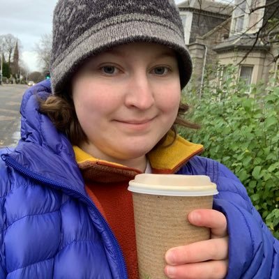 Young woman holds a disposable coffee cup