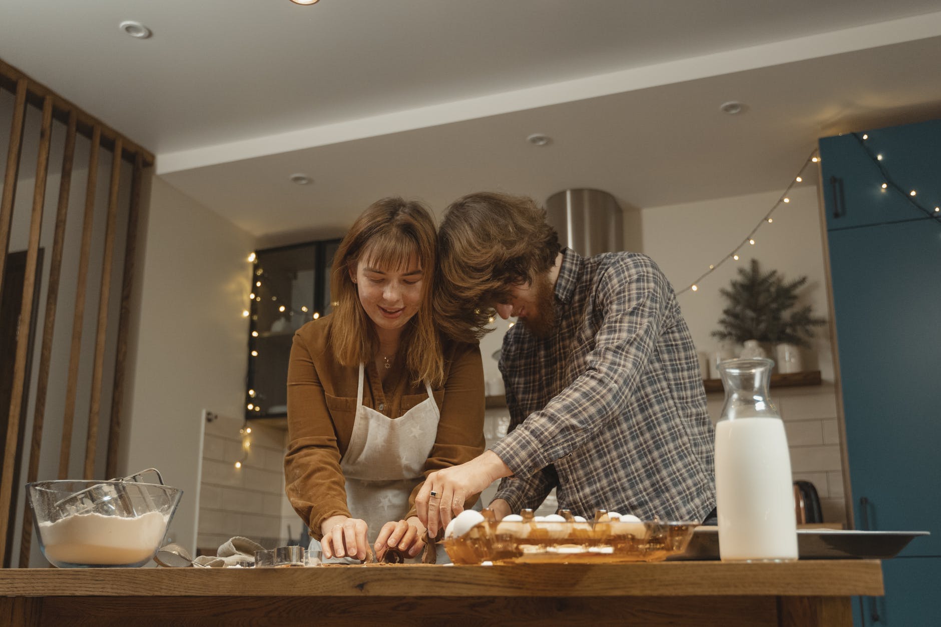 Two people bake in a small, cosy kitchen