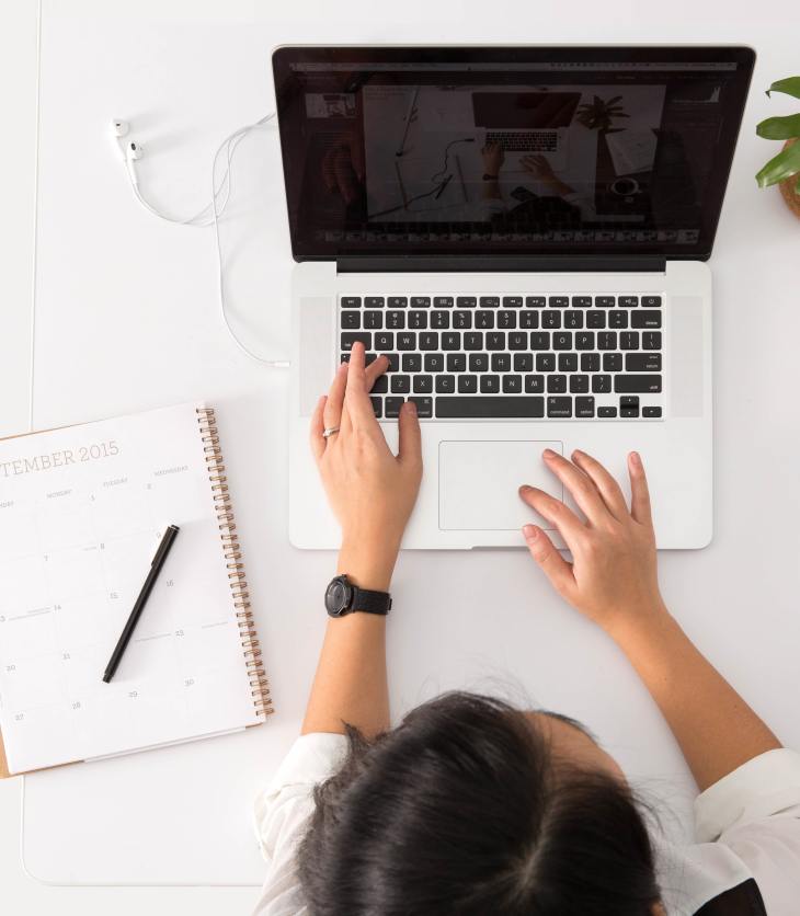 freelancer using a laptop and open diary- 6 things I love about being a freelancer