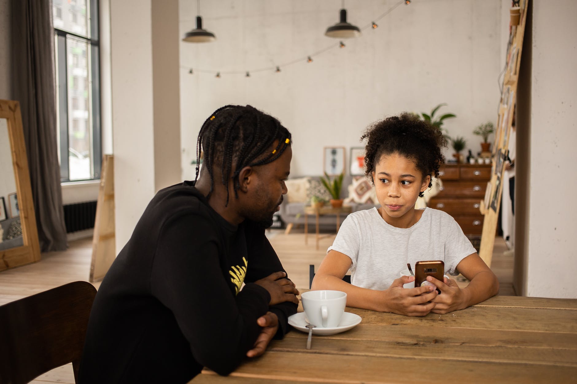 father talking to daughter about using smartphone and social media