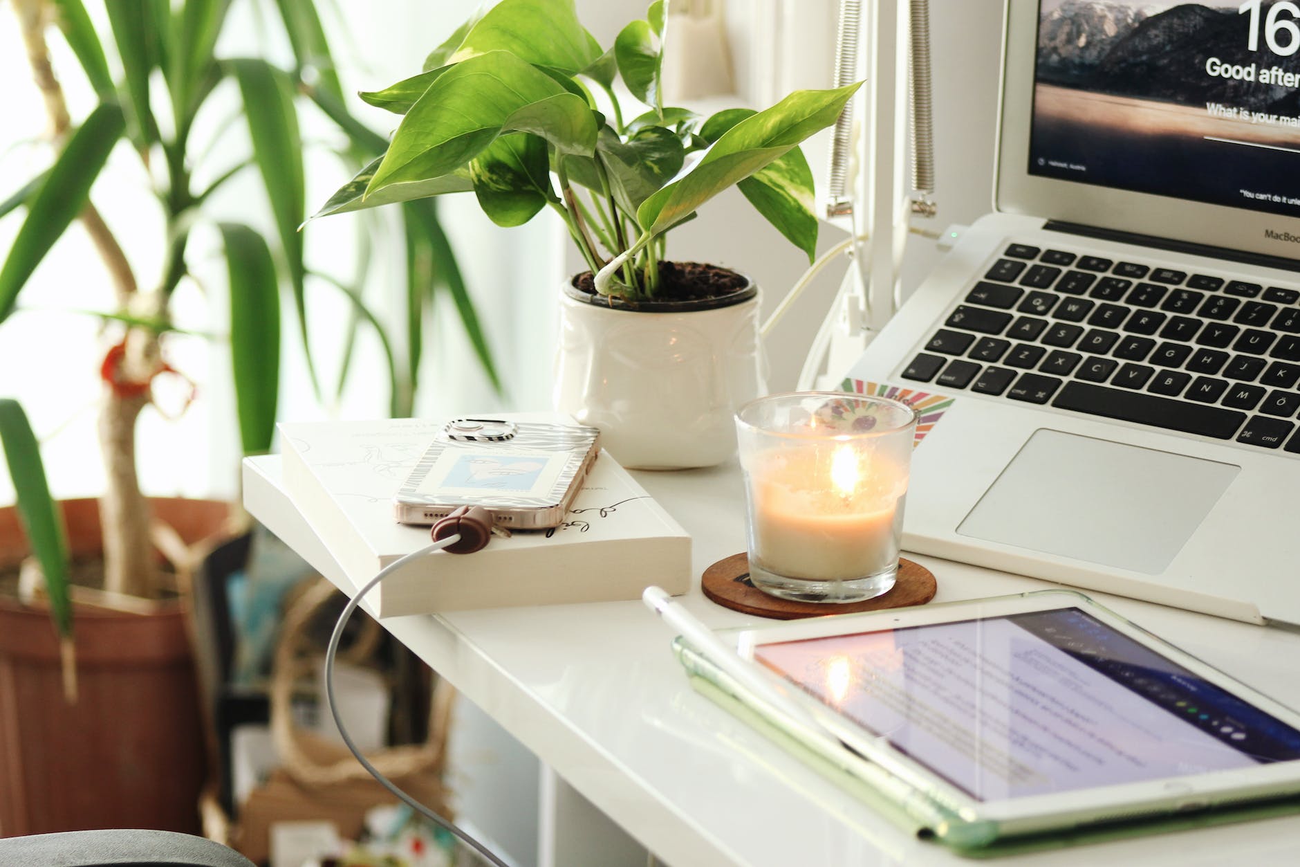 work space with candle and charging phone on desk