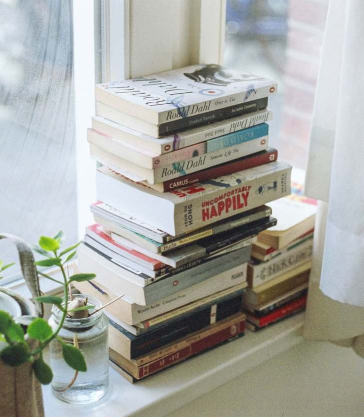 pile of books on a windowsill