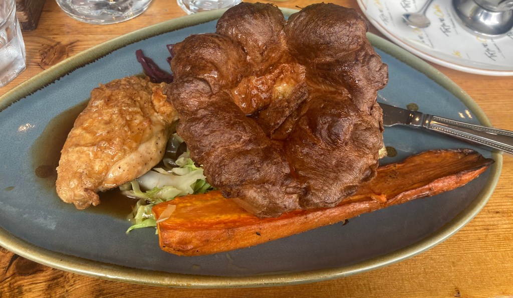 image of a roast dinner with a big Yorkshire pudding, chicken and carrot