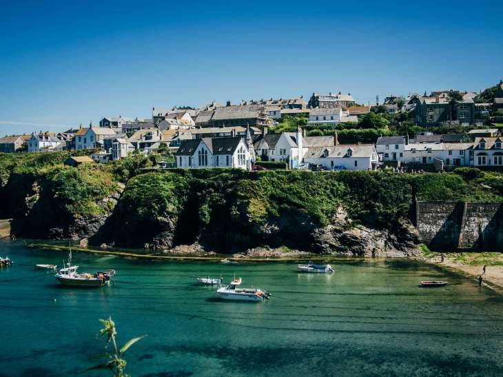 image of a Cornwall seascape with small boats and buildings on cliffs