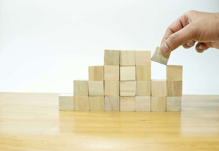 small wooden blocks being piled up by a hand