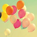 a bunch of multi-coloured balloons flying in the air