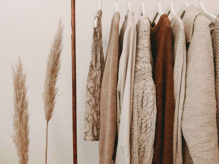 autumn jumper in soft brown colours lined up on a clothes rack