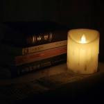 pile of books next to a fake candle