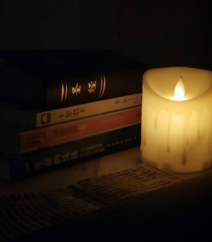 pile of books next to a fake candle