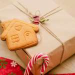 gift in brown parcel paper with a gingerbread biscuit, part of a stocking, and part of a candy cane