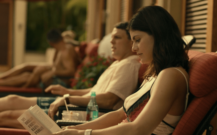 still from White Lotus 1 - image of a couple sitting by the pool, she's reading My Brilliant Friend by Elena Ferrante